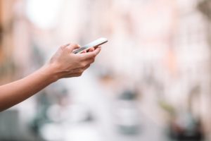 Closeup Of Female Hands Holding Cellphone Outdoors D3HL59L